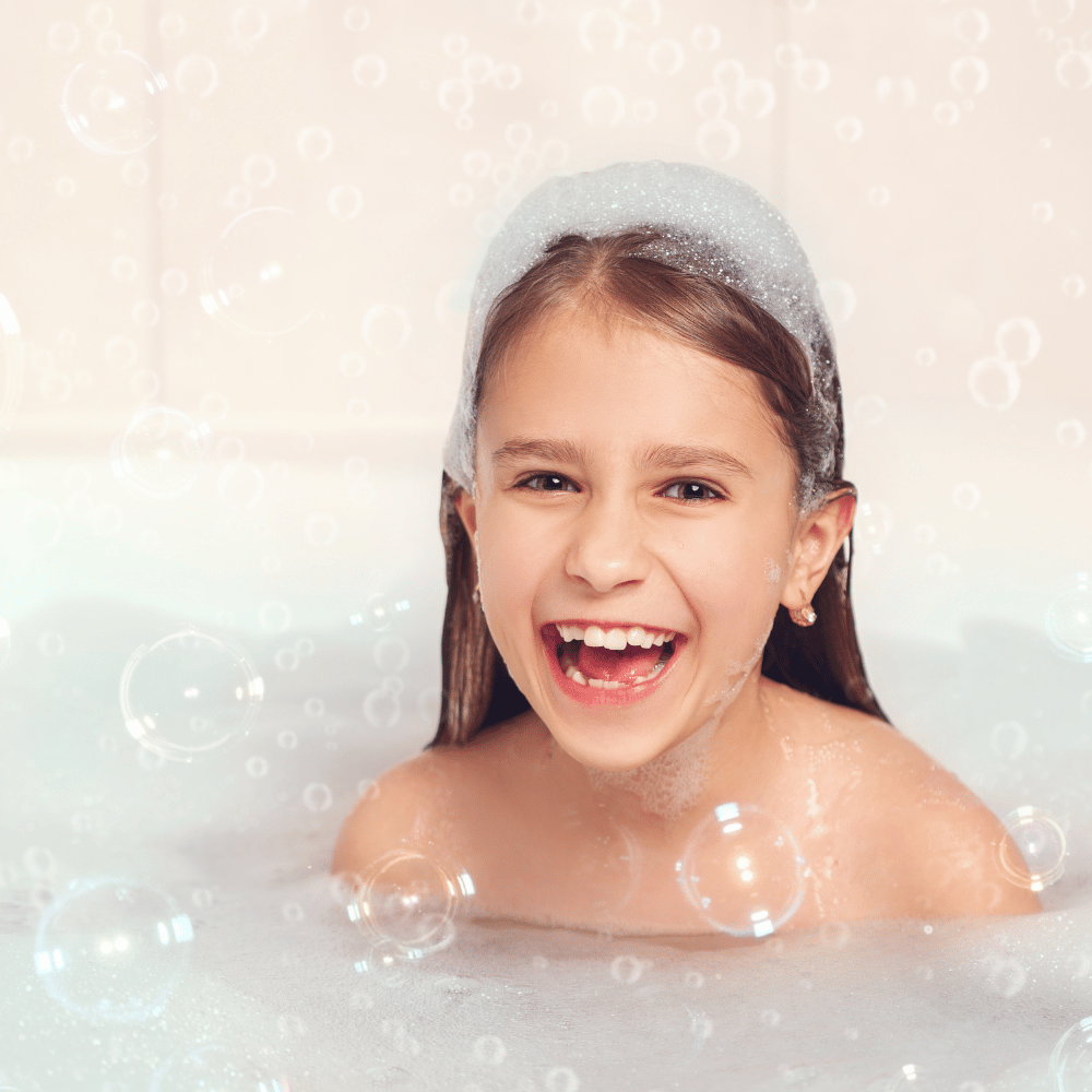 girl in bathtub with bubbles piled on top her head