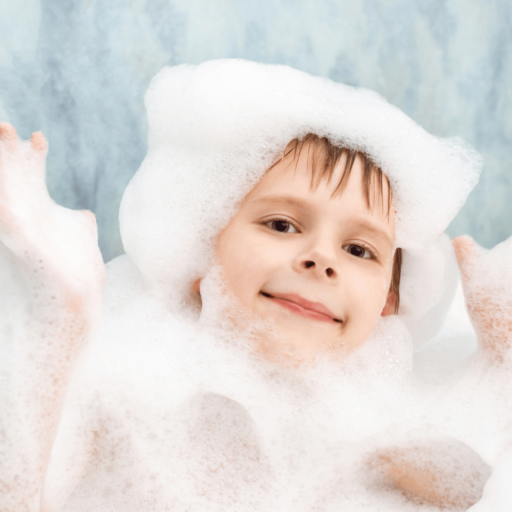 boy completely covered in bath bubbles