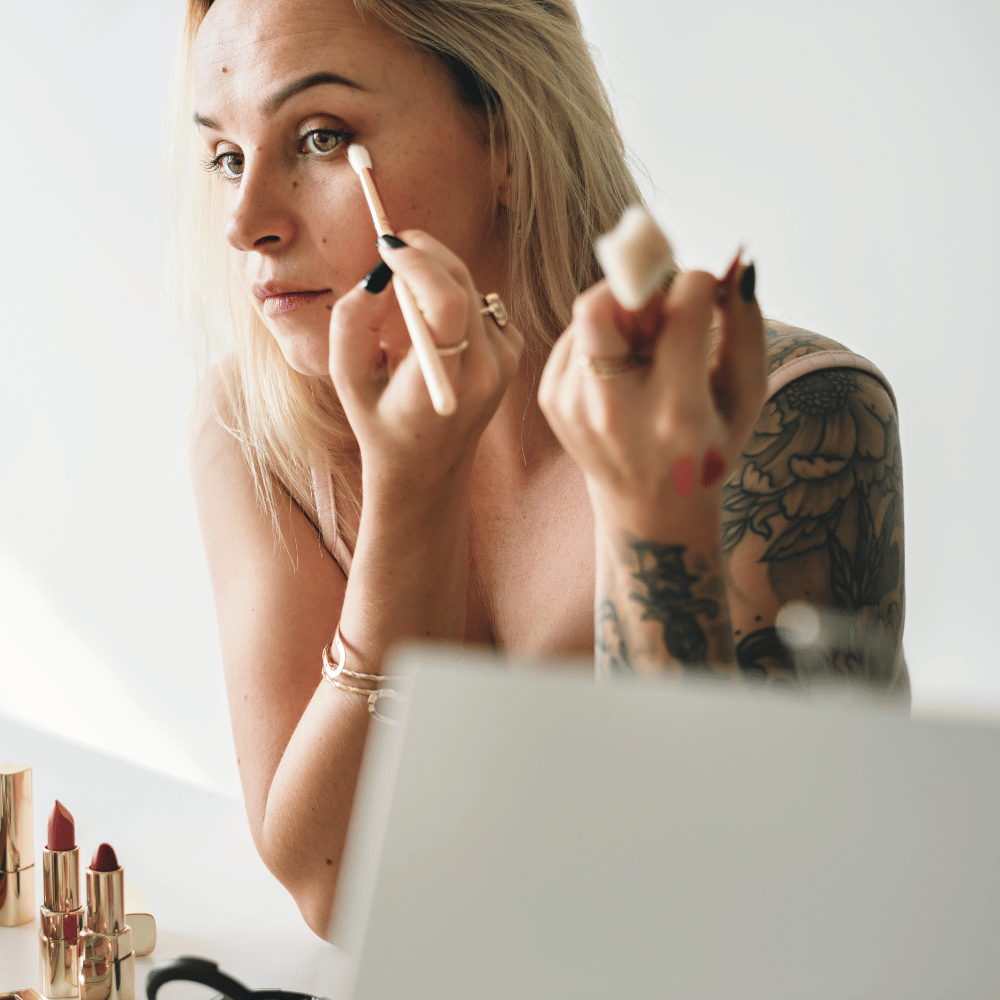 woman applying makeup in mirror