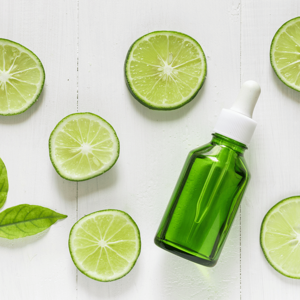 green bottle of serum with lime slices positioned around it