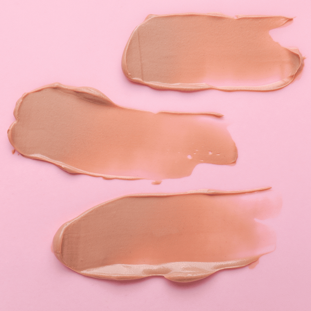 3 swatches of tinted moisturizer on a colored background
