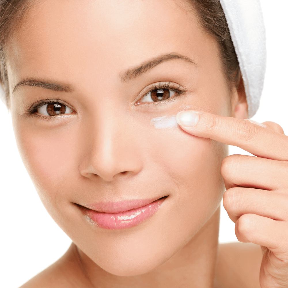 close up of woman putting on her eye cream
