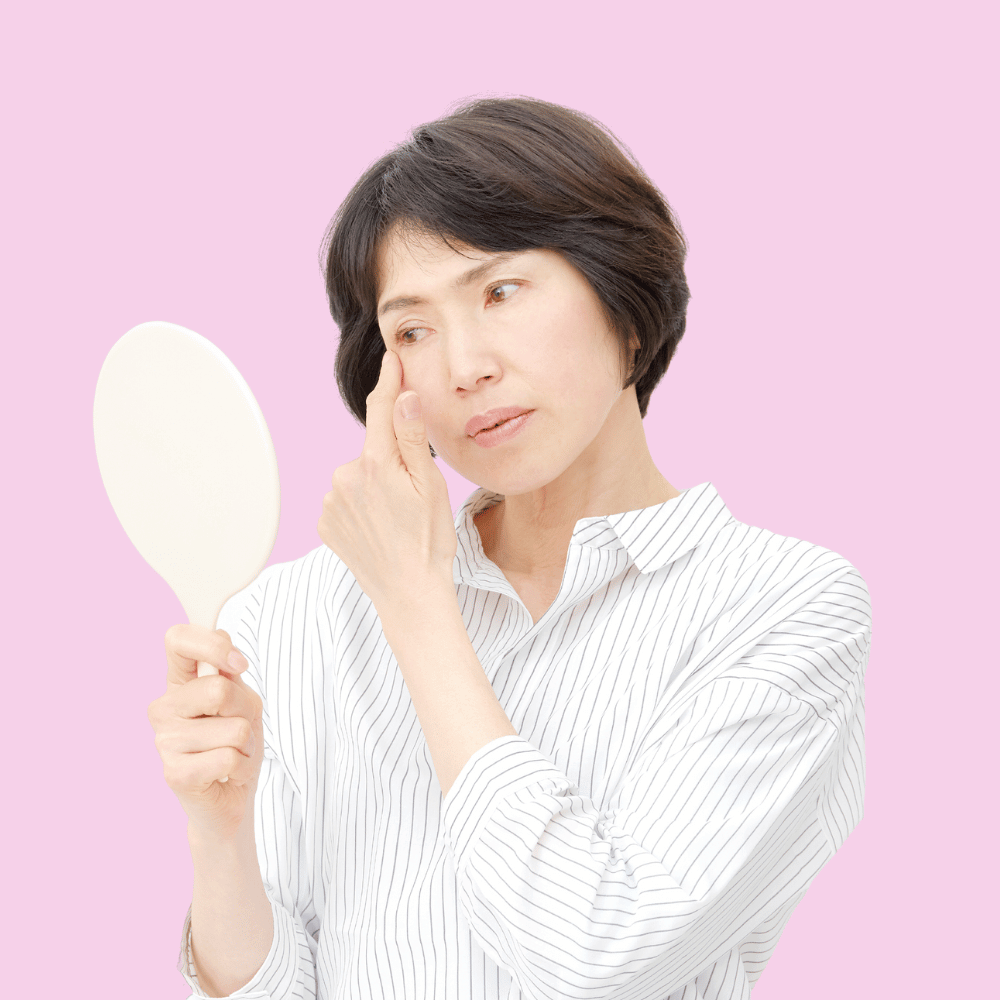 woman looking closely at her eye in a mirror