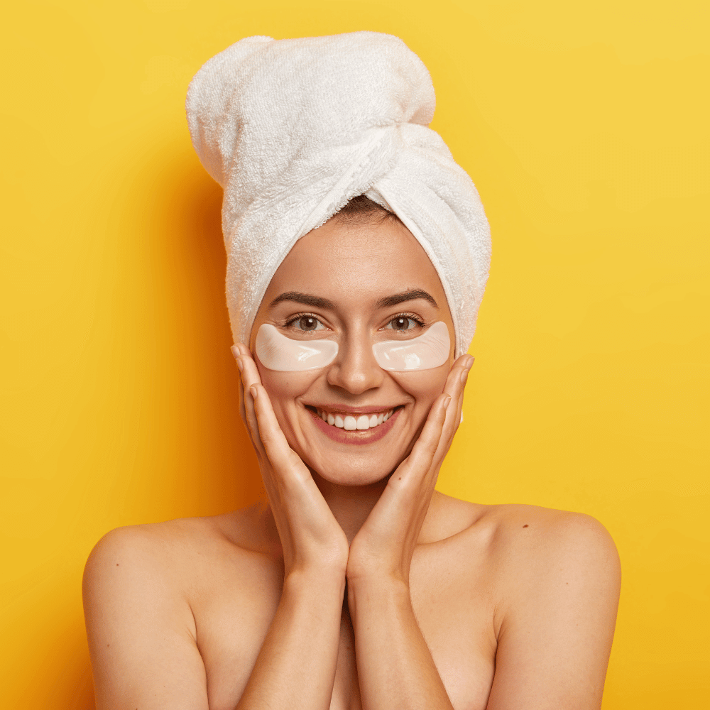 woman in hair towel with gel eye patches under her eyes