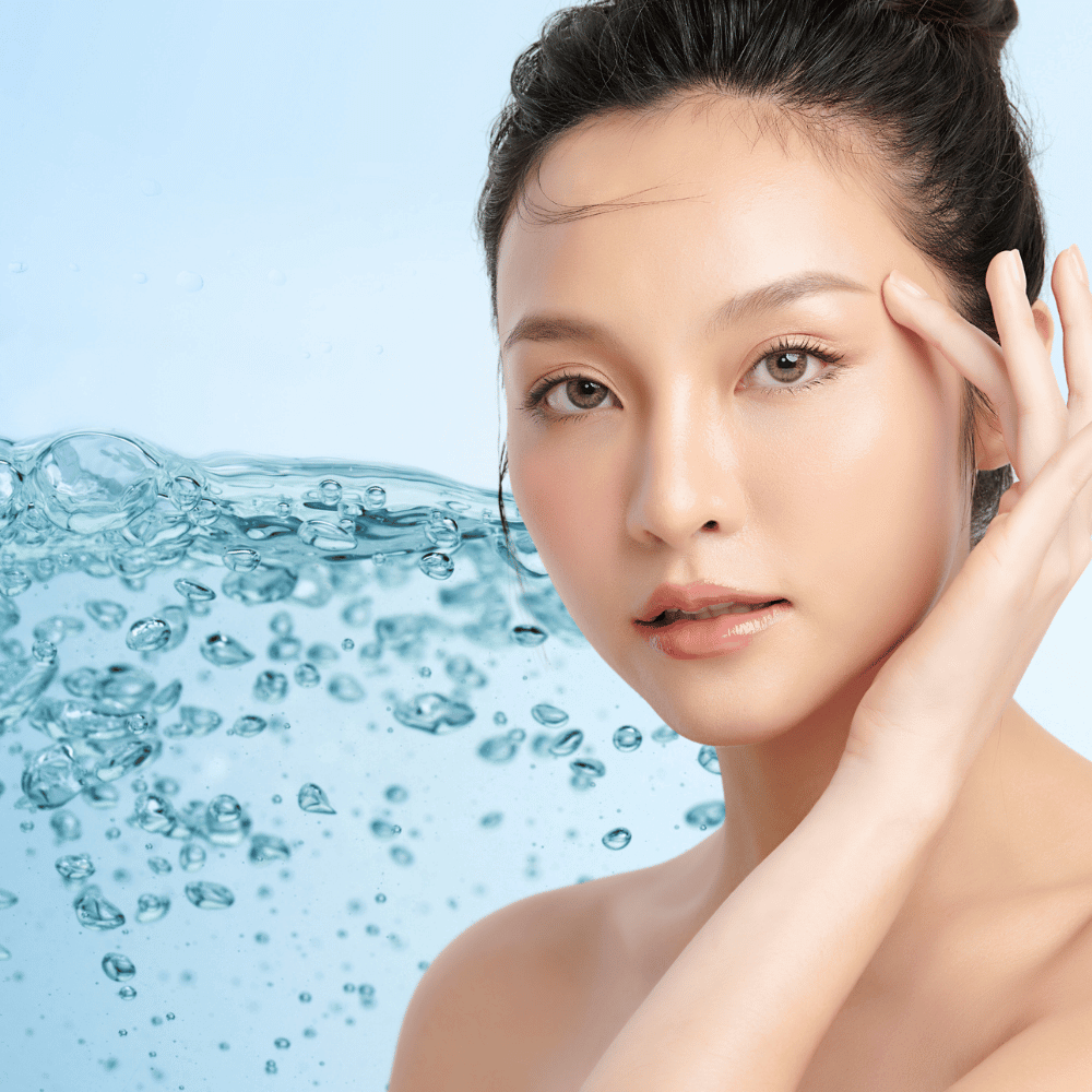 Korean woman with glowing hydrated skin with water and bubbles as background